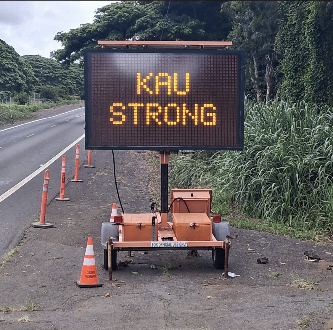 Handwritten whiteboard dated 8/21 headed Kokua Kau, listing community needs including canned food, hygiene products, propane, portable stoves, gas, baby items, paper goods, pet food and cleaning supplies.